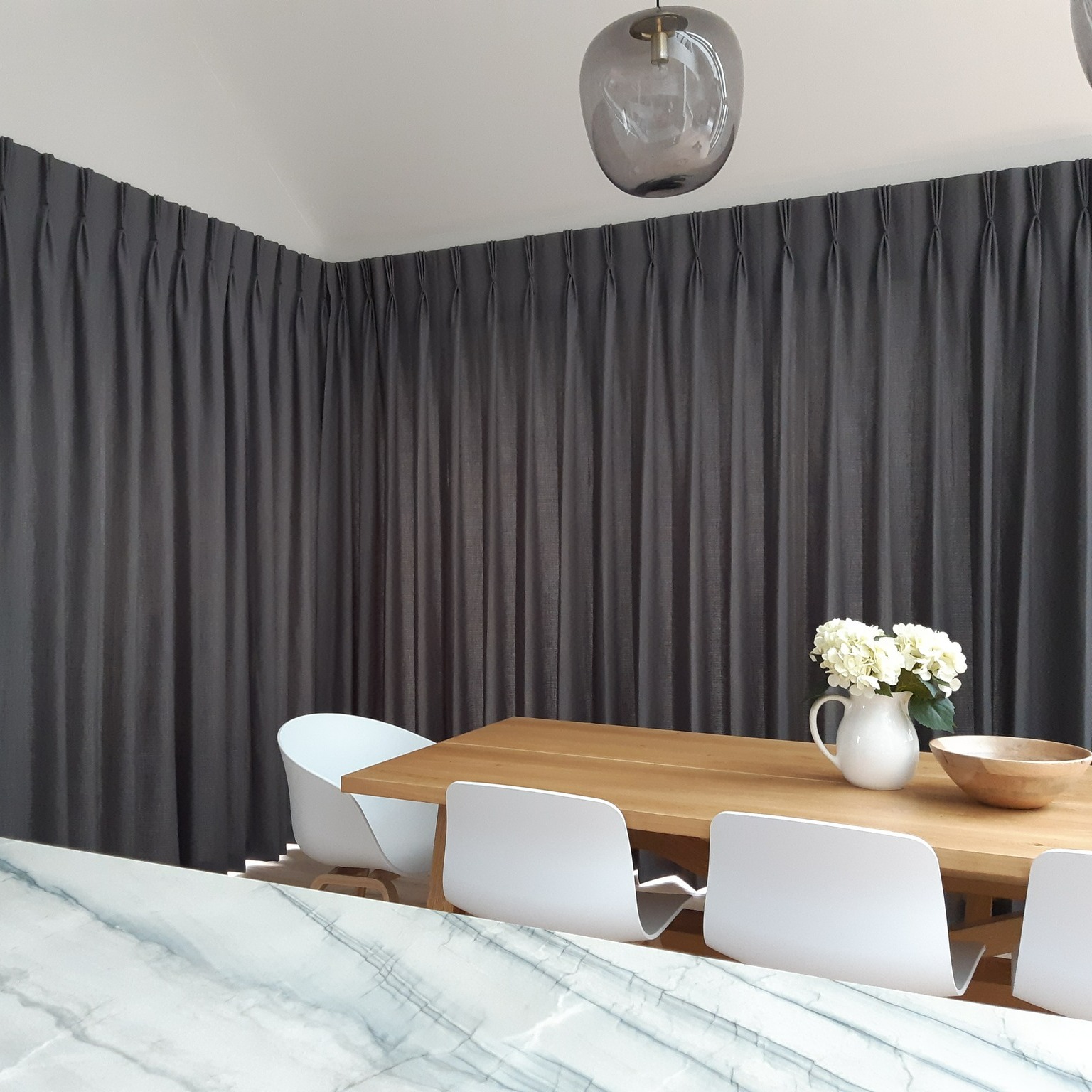 large corner window with french pleat curtains